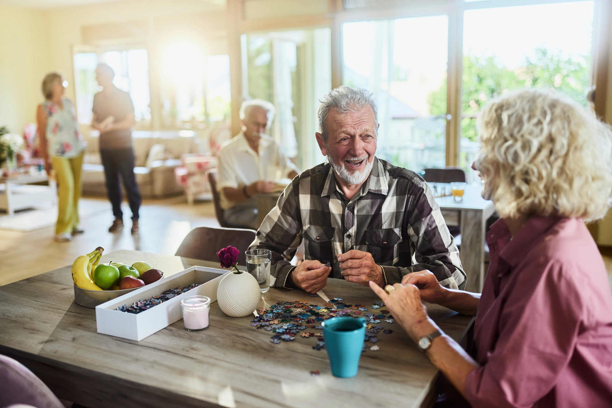 Residents enjoying puzzle time in a facility using low odor protective coatings for indoor air quality and comfort.
