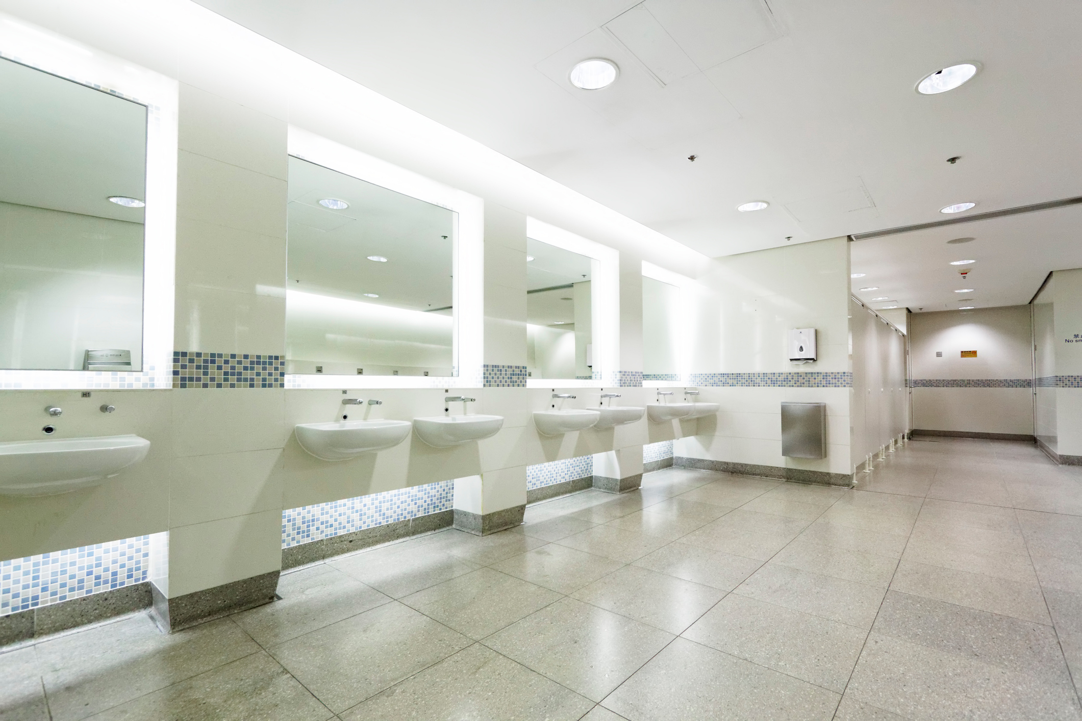 Modern commercial restroom interior featuring smooth, reflective wall panels and seamless flooring protected with plant-based, PFAS free, low VOC coatings for enhanced hygiene and durability.
