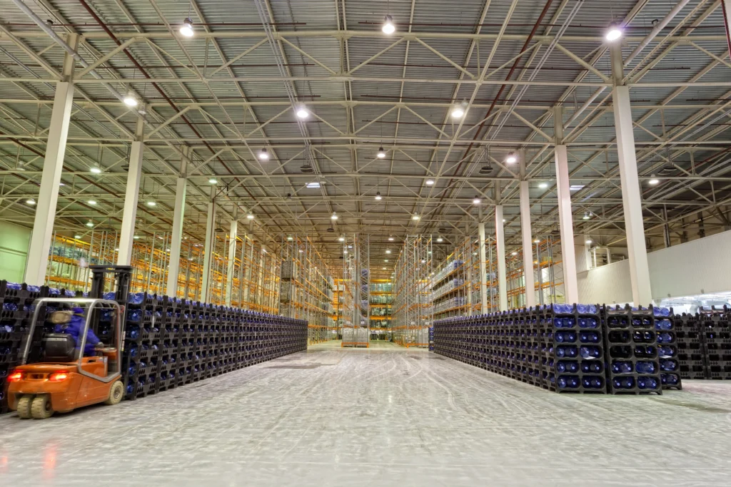Large industrial warehouse with coated concrete floors and material handling equipment, highlighting environments where coating contamination risks can occur.