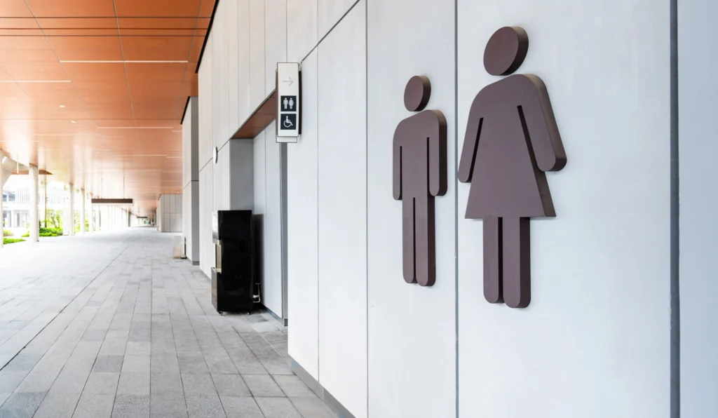 Public restroom entrance with restroom signage in a commercial facility, representing high-traffic environments that require durable surface protection.