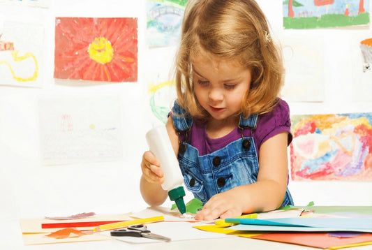 Young child using a school adhesive for an arts and crafts project, highlighting everyday classroom use and the importance of safer school adhesives.