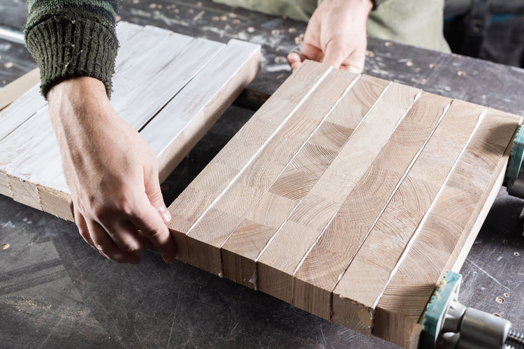Multiple wood boards bonded together with adhesive during panel lamination in a woodworking shop.
