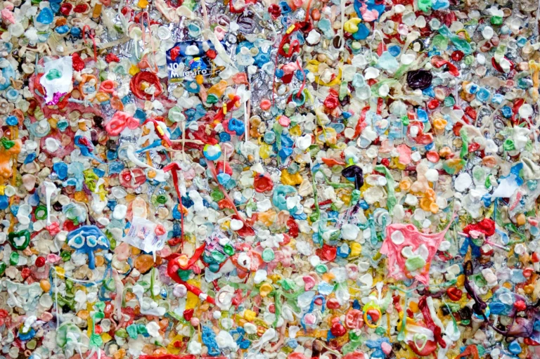 Wall covered in colorful gum pieces symbolizing contamination risks that microplastic-free coatings help prevent.
